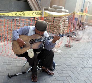 Exploring Lima: Using a homemade mic fashioned from an old telephone handset and wire, mounted inside his guitar, Manuel Pariachi, 72, performs a traditional Huayno song from his Andean homeland, Huancayo