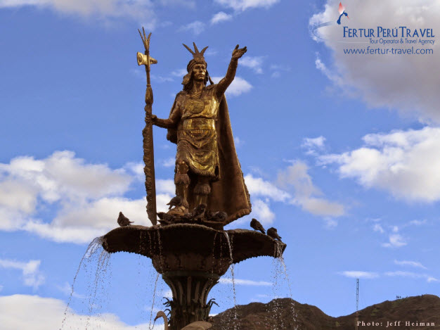 The sun glints off the golden colored statue of Inca Pachacutec in Cusco's main plaza
