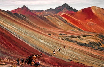 Small tour groups hikes the lower slopes of the multi-colored Vinicunca mountain range