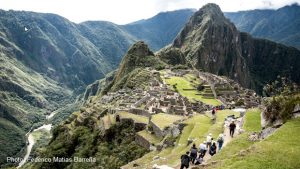 An example of Machu Picchu photography: visitors walking the narrow terrace above the Inca Citadel with the Huayna Picchu peak towering in the background.