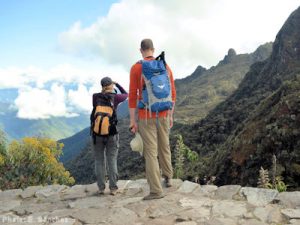 A couple stop to take in the view and take photos during their hike of the Inca Trail. Currently masks aren't required during most of the hike.