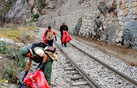 Local residents clean pastic bottles and other waste from the train tracks leading to Machu Picchu. 