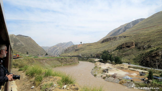 Passenger takes photos of Peru's Central Andean highlands from the Observation Car of the Cental Andean Railway between Lima and Huancayo - Peru