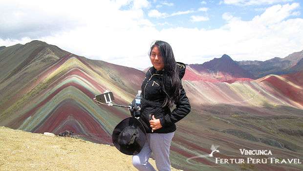 Photo of young woman on top of Rainbow Mountain