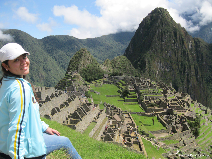 A tourists sits, overlooking Machu Picchu, a UNESCO World Heritage Site and one of the most iconic ancient cities in the world. The Incan citadel, perched high in the Andes Mountains of Peru, is renowned for its masterful stonework, temples, palaces, and terraces.