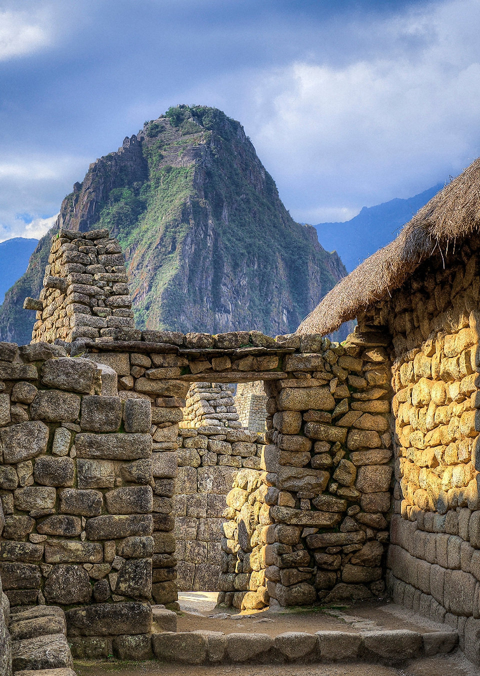 Huayna Picchu peak seen from the storage houses of Machu Picchu near dusk.