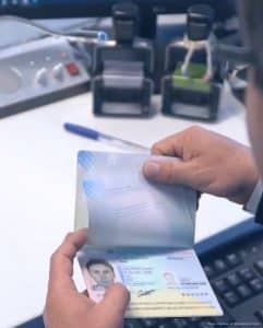 Peruvian immigration official inspects passport at land border crossing with Bolivia