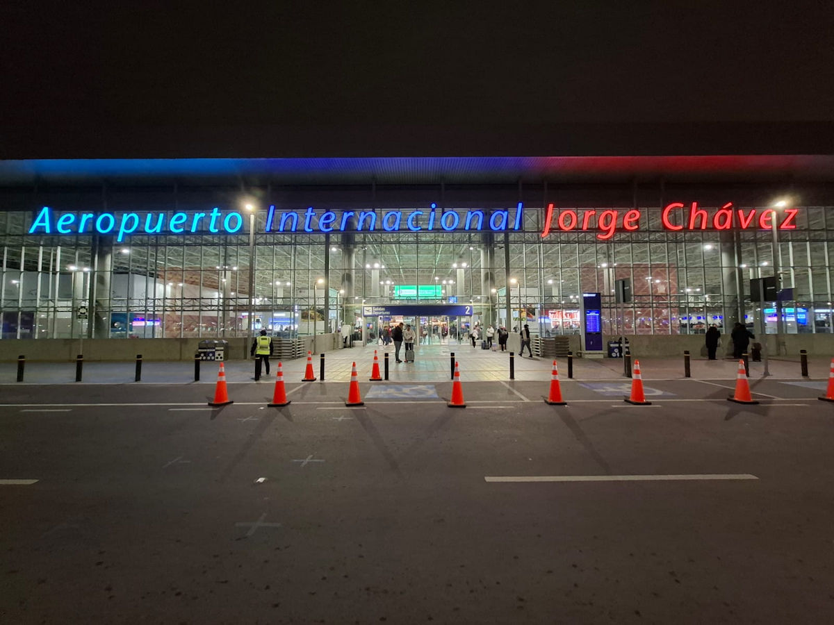 Jorge Chavez International Airport, Lima Peru | Peru Travel Blog Exterior of Jorge Chávez International Airport in Lima, Peru, at night, with its illuminated blue and red sign reading Aeropuerto Internacional Jorge Chávez. Go to the airport armed with information about airline passenger rights in Peru.