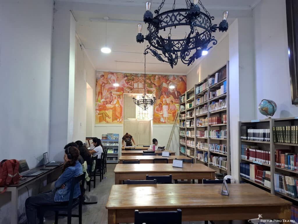 Interior of the Biblioteca Municipal de Barranco, Lima | Peru Travel Blog The reading room of the Biblioteca Municipal de Barranco, dating to 1922, with its wrought-iron chandelier, wooden reading tables and large figurative mural. Photo by Fertur Peru Travel.