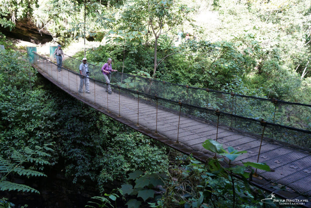 Suspension Bridge on Gocta Falls trail near Cocachimba / San Pablo, Amazonas, Peru | Peru Travel Blog Hikers heading to Gocta Falls cross a narrow suspension bridge through dense green jungle near Cocachimba / San Pablo, Amazonas, Peru. Photo: Sameh Fakhouri