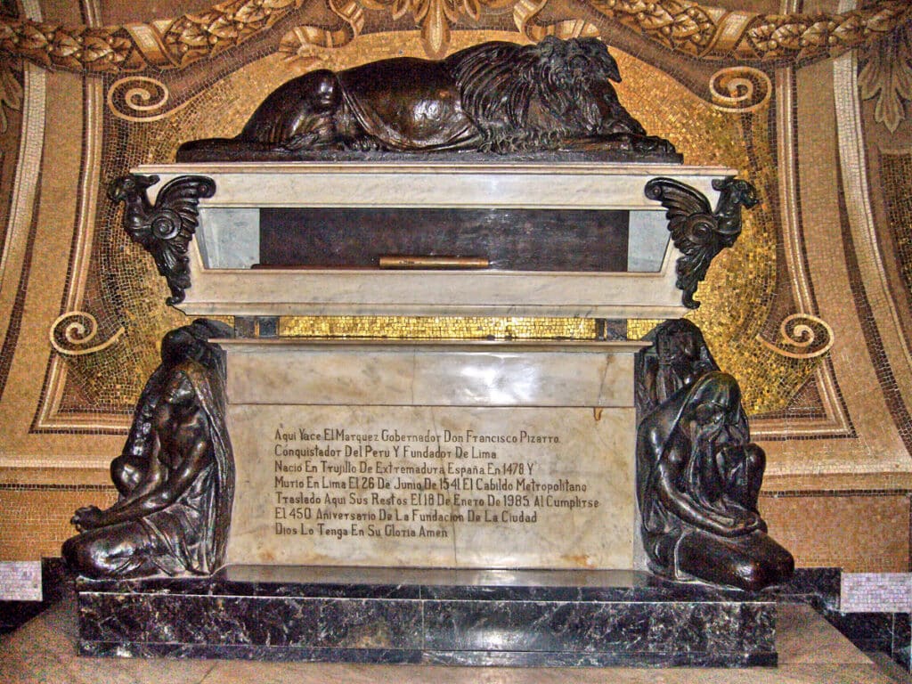 Tomb of Francisco Pizarro, Lima Cathedral, Peru | Peru Travel Blog The ornate marble and bronze tomb of Francisco Pizarro inside the Lima Cathedral, flanked by two kneeling bronze mourner figures and topped by a reclining lion, set against an elaborate golden mosaic backdrop. The tomb inscription identifies him as Conqueror of Peru and Founder of Lima, born in Trujillo de Extremadura, Spain in 1478, and died in Lima on June 26, 1541. Photo: © Manuel González Olaechea y Franco (Creative Commons).