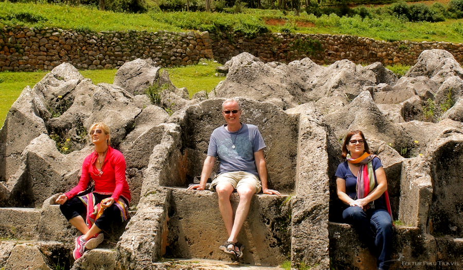 Clientes de Fertur Perú Travel sentados en los tronos incas excavados en la roca del Templo del Rayo, cerca de Cusco - Perú 