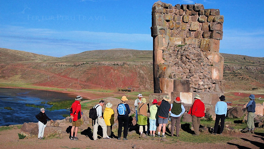 Un grupo turístico de Fertur con su guía en una de las "chullpas" funerarias de Sillustani en Puno - Perú  