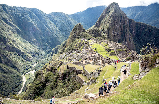 Tourists view the Sanctuary of Machu Picchu and the Huayna Picchu peak from an upper Inca terrace