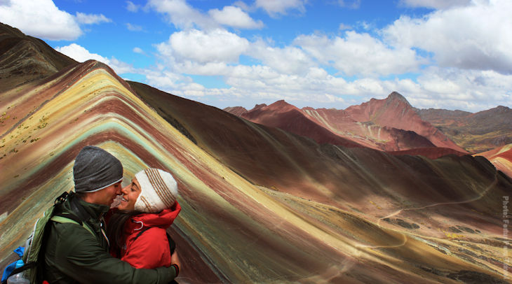 Una pareja de viajeros celebra en la montaña Arco Iris durante sus viajes de aventura en Perú