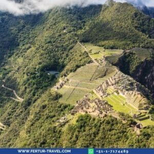 Machu Picchu Inca ruins seen from above with green Andean peaks and clouds on a 4 days 3 nights tour from Cusco