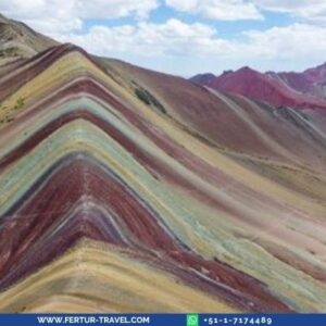 Vista panorámica de la Montaña de Vinicunca o Montaña Arco Iris, con sus inconfundibles franjas de colores minerales en tonos rojo, verde, amarillo y turquesa en los Andes del Cusco — el paisaje extraordinario que usted contemplará en este trek de 4 días.