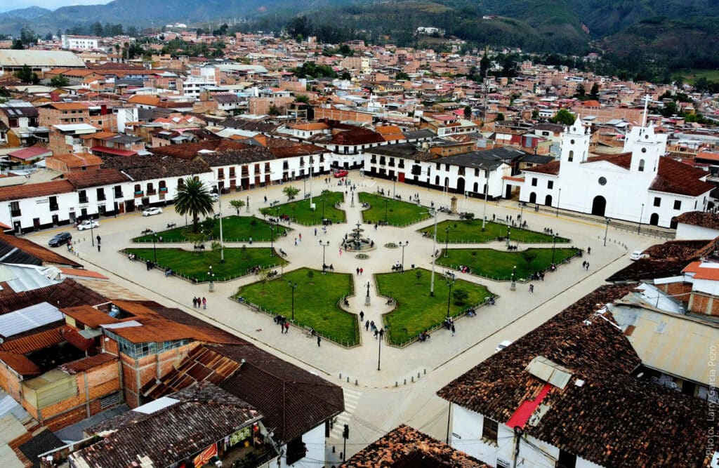 Vista aérea de la Plaza de Armas y la catedral colonial de Chachapoyas, con los tejados de terracota de la ciudad y las verdes montañas andinas que rodean la capital de la región Amazonas, Perú.