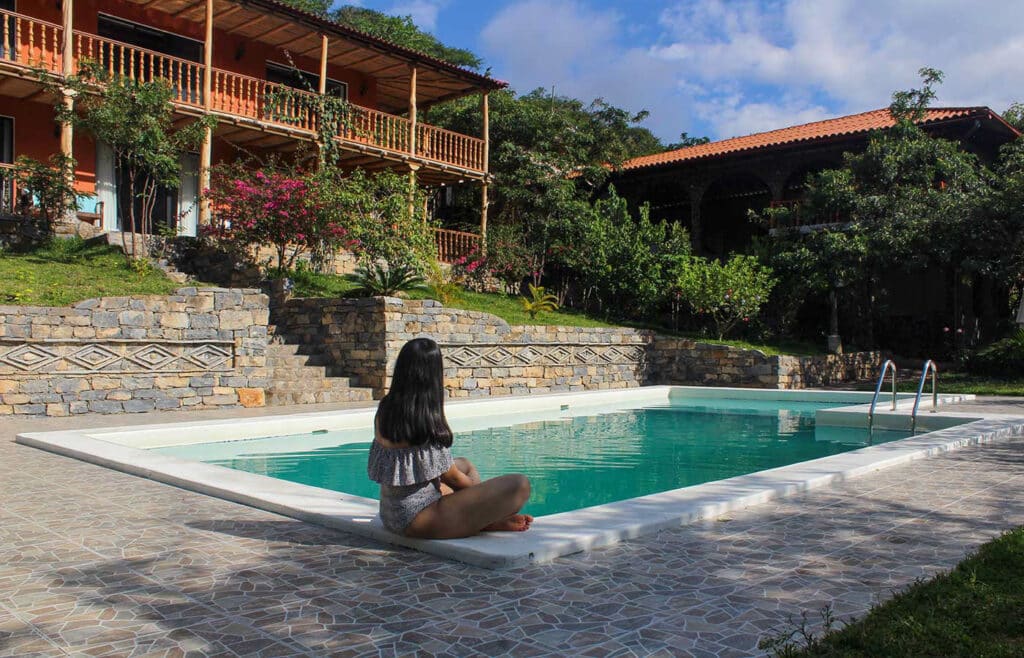 Woman relaxing by the outdoor swimming pool at Utcubamba River Lodge, an eco-lodge in the Chachapoyas region of Peru