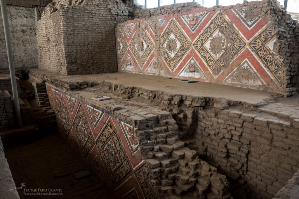 Brilliantly preserved polychrome murals in red, gold, and white geometric patterns adorn the ancient adobe walls and terraces of Huaca de la Luna, a Moche ceremonial site near Trujillo, Peru.
