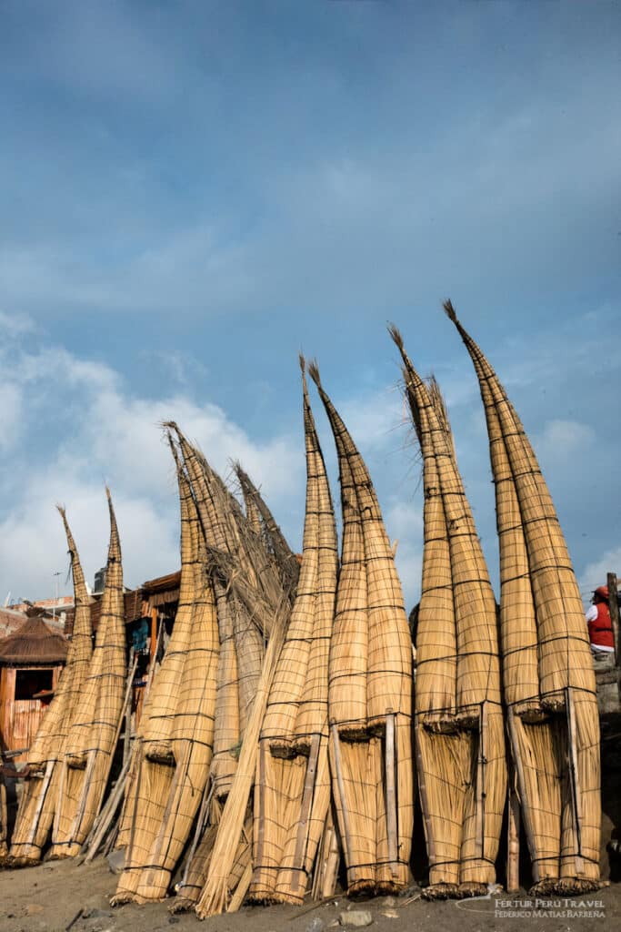 Caballitos de totora alineados en la playa de Huanchaco, Trujillo, Perú
