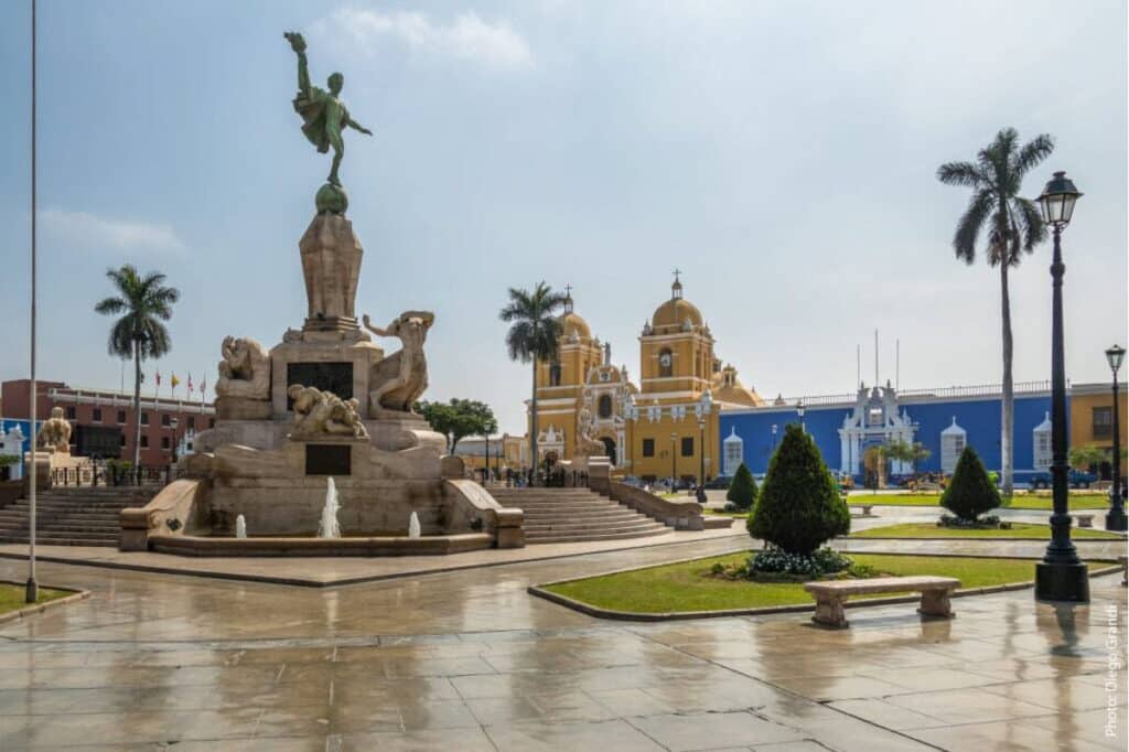 La Plaza Mayor de Trujillo con su monumento central, la catedral colonial y los edificios azules que bordean la plaza principal de Trujillo, Perú.